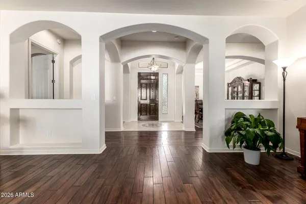 a view of a hallway with wooden floor and a potted plant