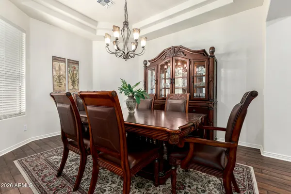 a view of a dining room with furniture a chandelier and wooden floor