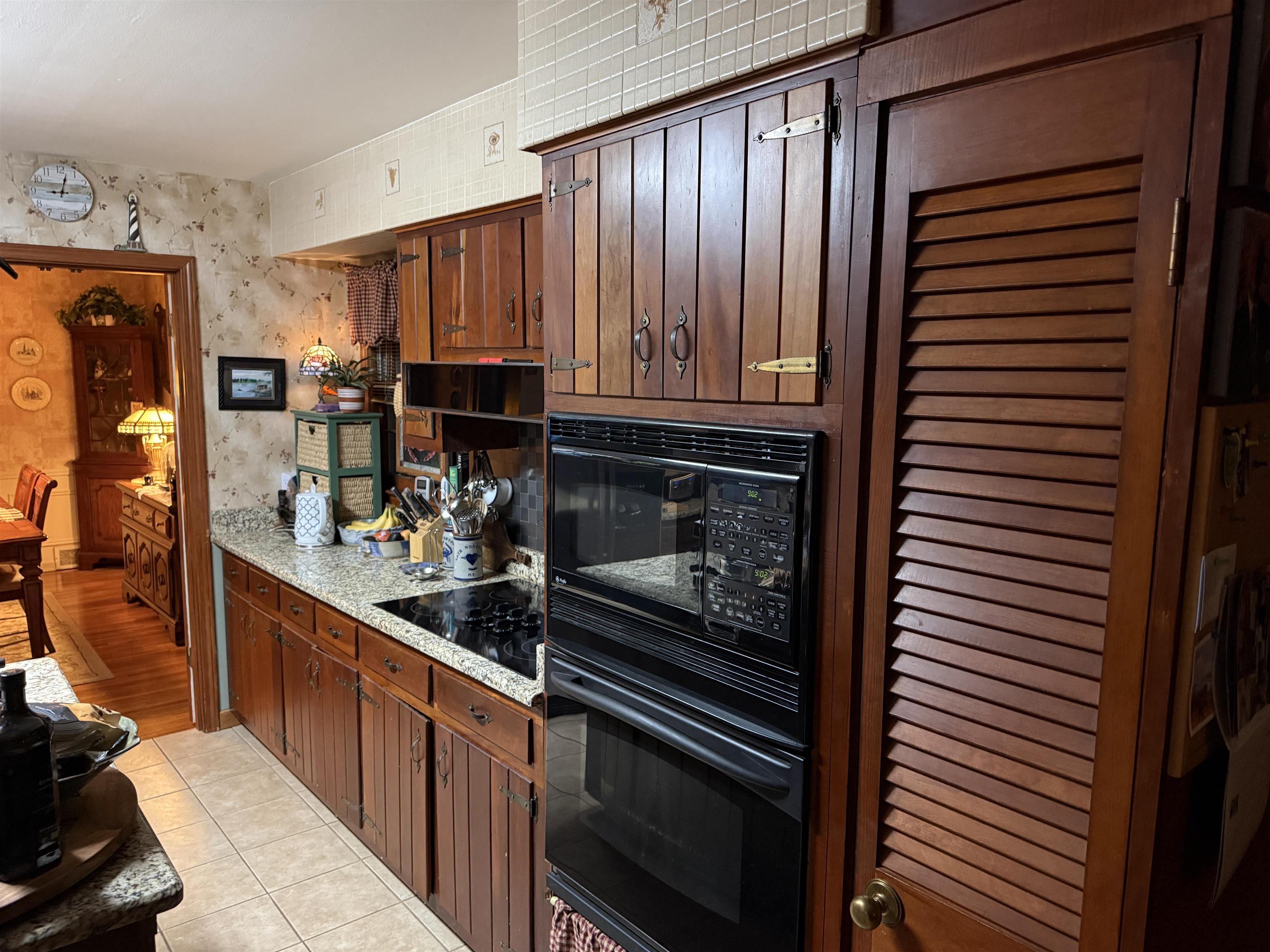 3194 Lammermuir Road Memphis, TN 38128 - Photo 16 of 37 Kitchen featuring wood cabinetry, built-in wall oven and microwave, a smooth cooktop, and speckled granite countertops