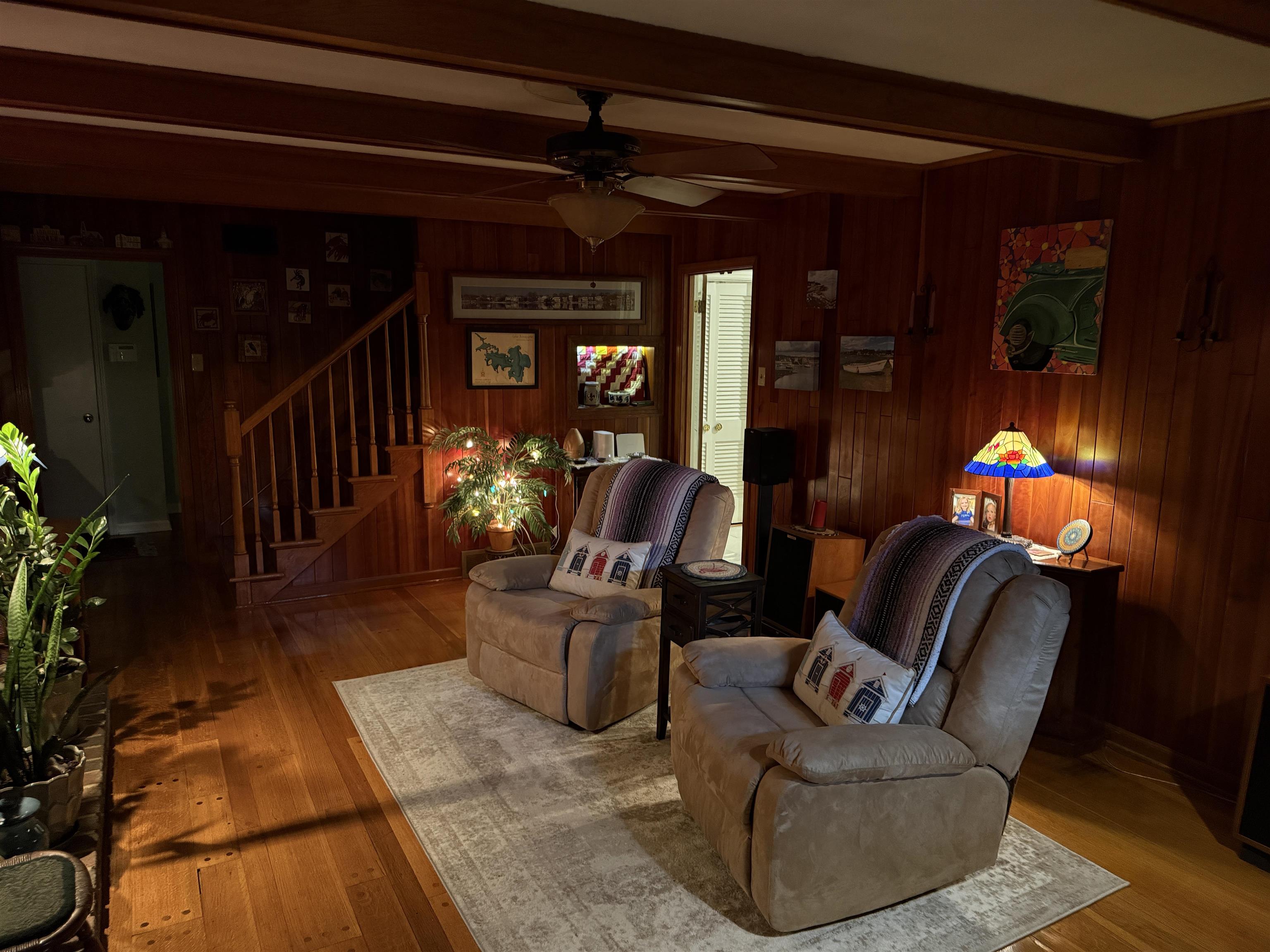 3194 Lammermuir Road Memphis, TN 38128 - Photo 18 of 37 Wood-paneled room featuring a staircase with a wood railing and risers, wood-finish flooring, and a ceiling fan with integrated lighting
