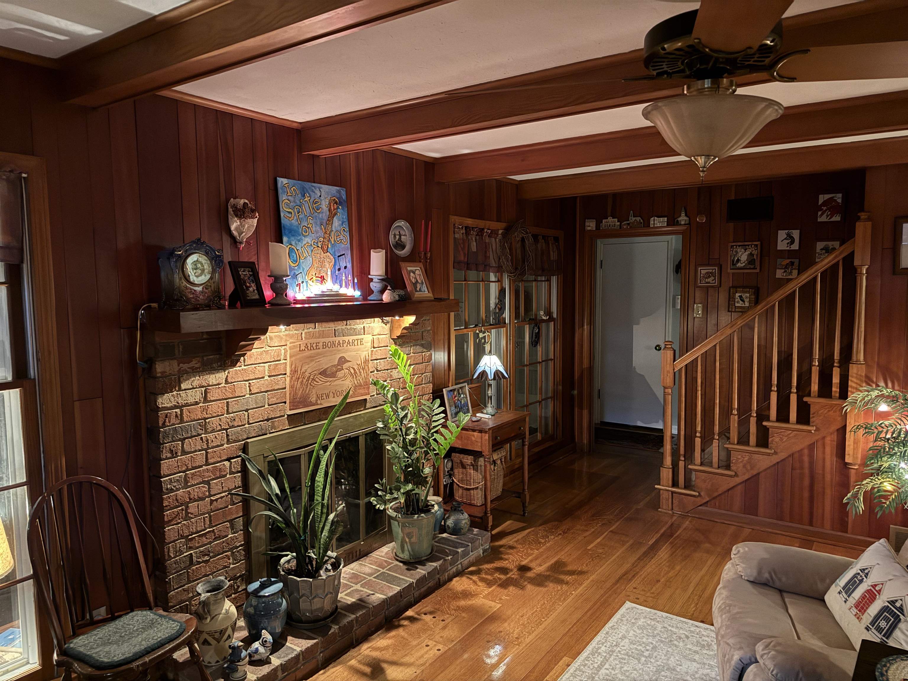 3194 Lammermuir Road Memphis, TN 38128 - Photo 19 of 37 Brick fireplace with a wood mantel, wood-paneled walls, exposed wood beams, wood-finish flooring, and a wood staircase with balusters