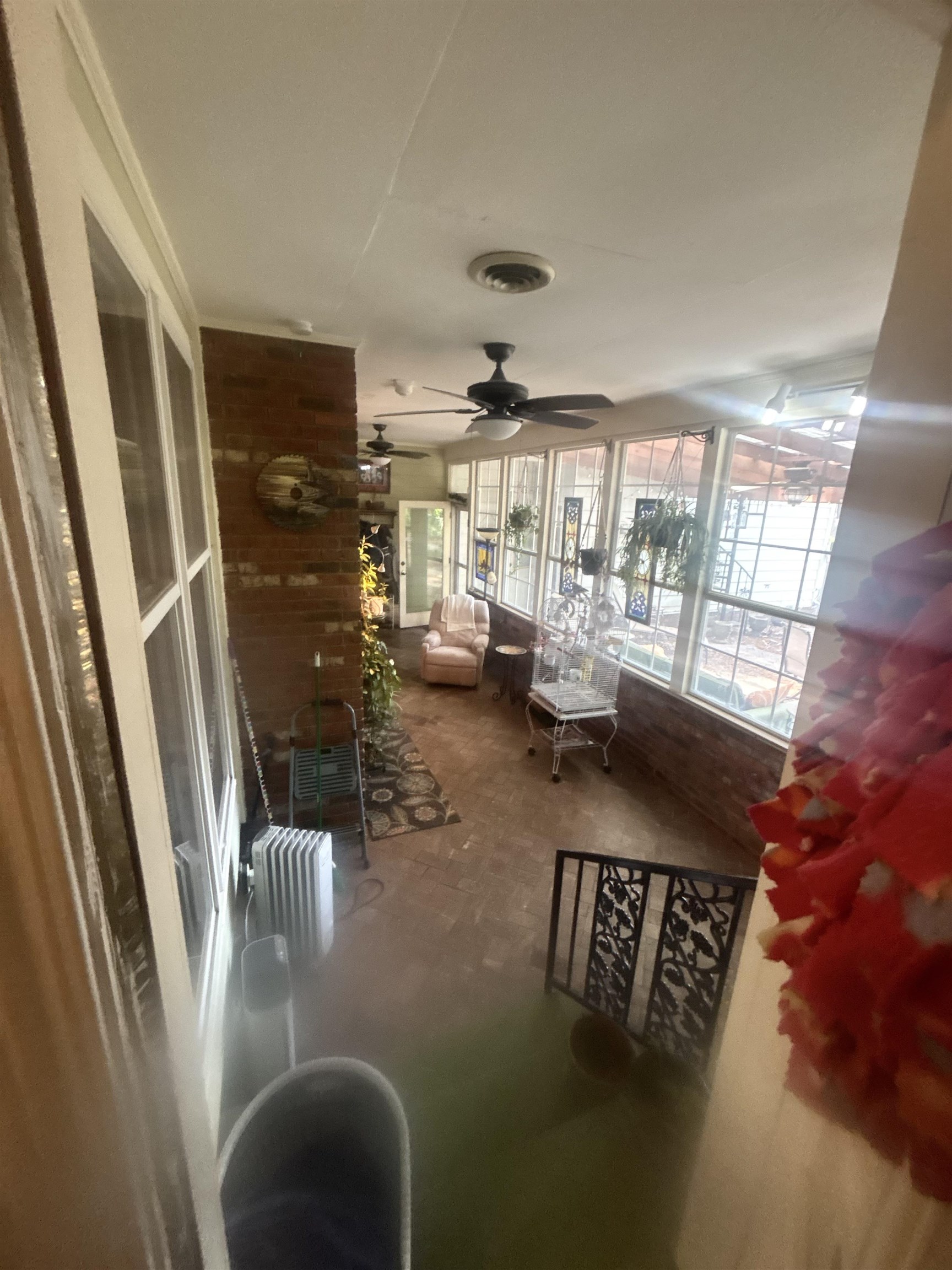 3194 Lammermuir Road Memphis, TN 38128 - Photo 34 of 37 Sunroom with multiple windows, two ceiling fans, brick accent wall, and patterned wrought iron railing