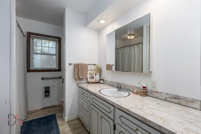 a bathroom with a granite countertop sink and a mirror