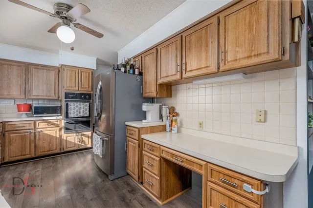 a kitchen with stainless steel appliances granite countertop a refrigerator sink and stove