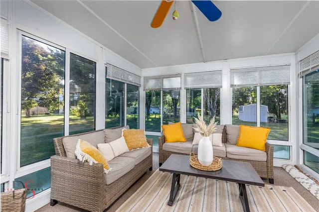 a living room with furniture and floor to ceiling windows