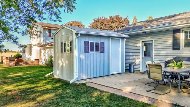 a backyard of a house with table and chairs