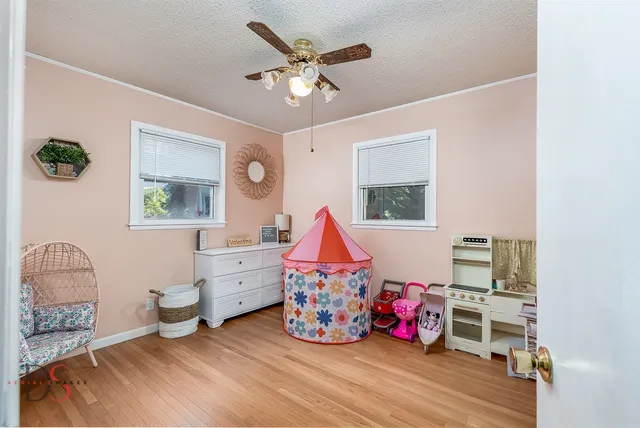 a living room with baby crib furniture and a window