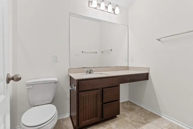 a bathroom with a toilet a sink and mirror