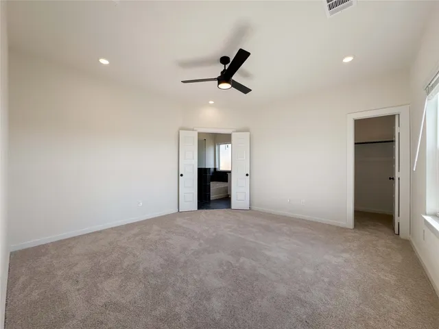 an empty room with closet and windows
