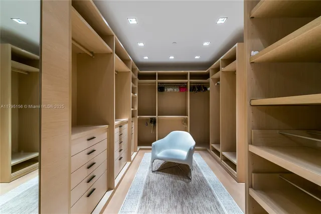a view of walk in closet and wooden furniture