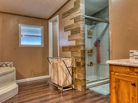 6341 Farm Private Road Levelland, TX 79336 - Photo 20 of 46 a bathroom with a granite countertop shower a sink and a mirror