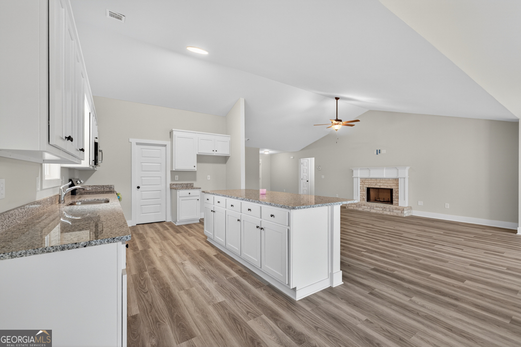 274 Mockingbird Lane, Unit 27 Winder, GA 30680 - Photo 12 of 29 a kitchen with granite countertop a sink dishwasher a stove and a refrigerator with wooden floor