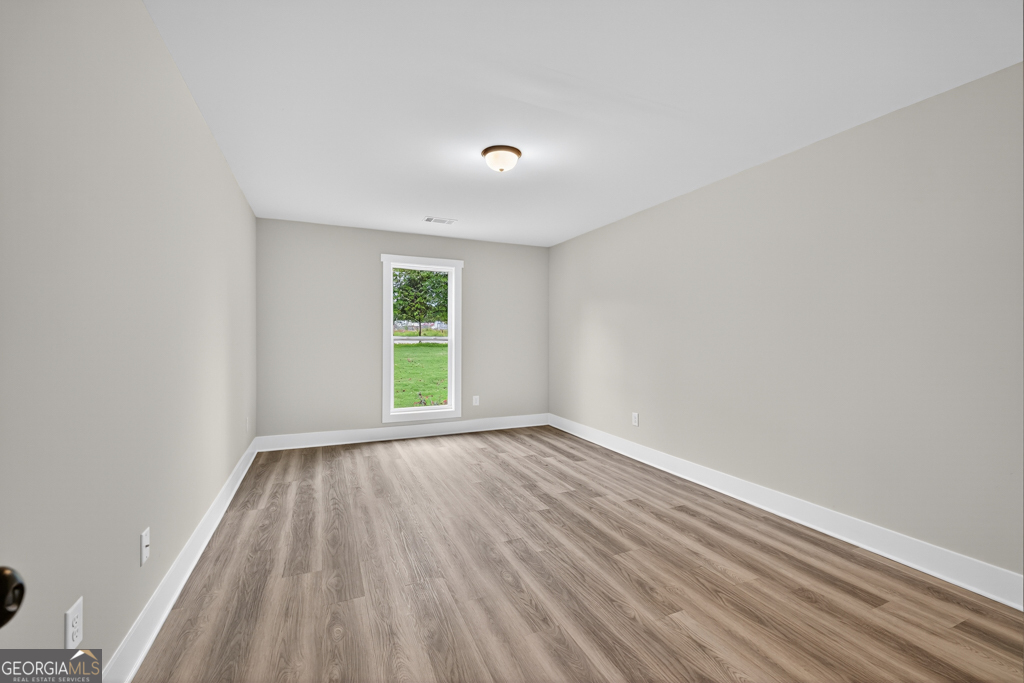 274 Mockingbird Lane, Unit 27 Winder, GA 30680 - Photo 16 of 29 a view of an empty room with wooden floor and a window