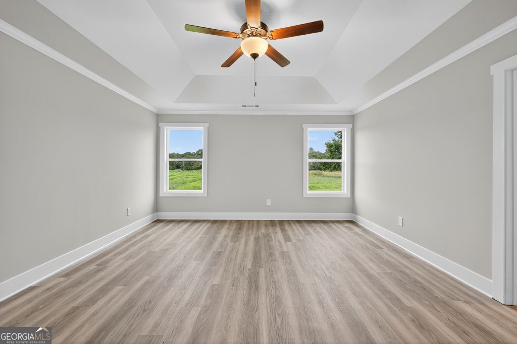 274 Mockingbird Lane, Unit 27 Winder, GA 30680 - Photo 21 of 29 an empty room with wooden floor ceiling fan and windows