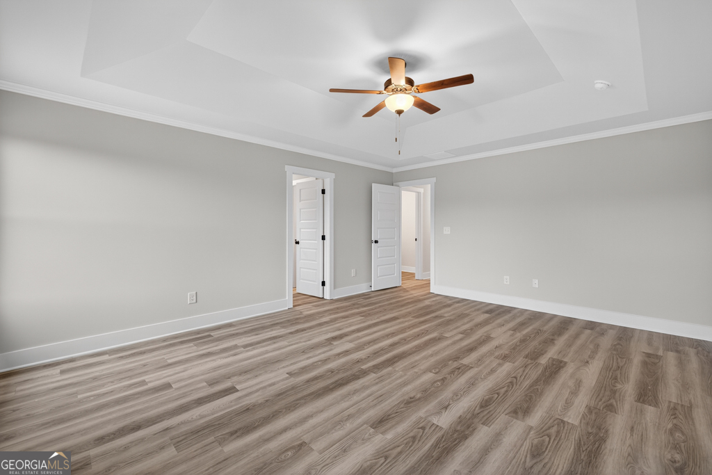 274 Mockingbird Lane, Unit 27 Winder, GA 30680 - Photo 22 of 29 a view of an empty room with wooden floor and a ceiling fan