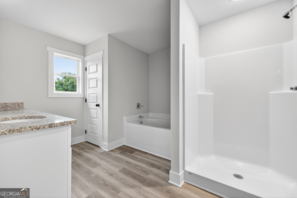 274 Mockingbird Lane, Unit 27 Winder, GA 30680 - Photo 23 of 29 a bathroom with a granite countertop sink a bathtub and next to a window