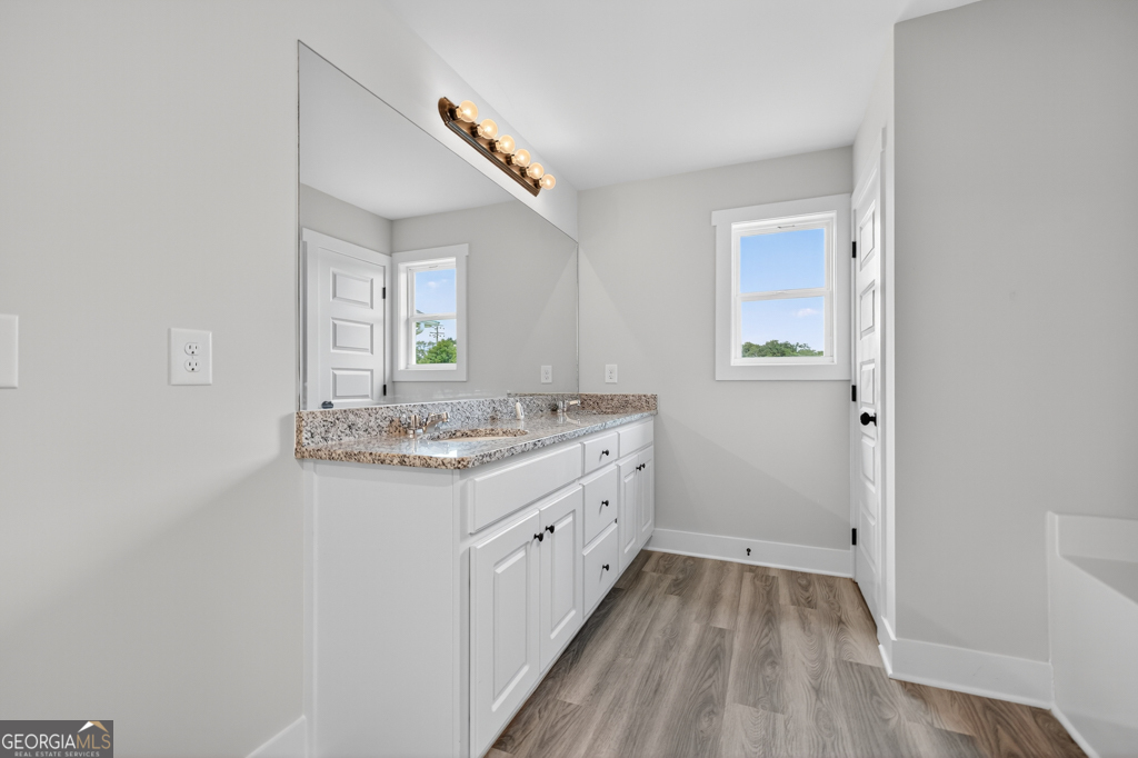 274 Mockingbird Lane, Unit 27 Winder, GA 30680 - Photo 24 of 29 a bathroom with a granite countertop sink and a mirror