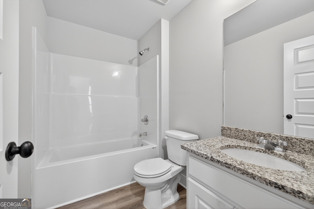 274 Mockingbird Lane, Unit 27 Winder, GA 30680 - Photo 28 of 29 a bathroom with a granite countertop toilet a sink and a bathtub