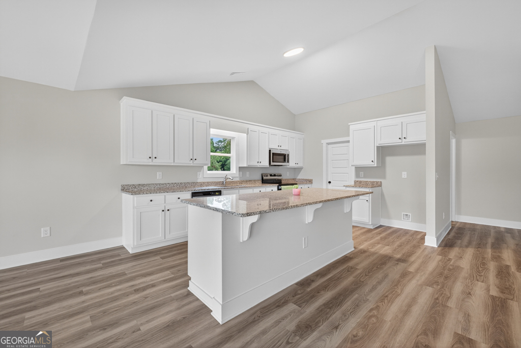 274 Mockingbird Lane, Unit 27 Winder, GA 30680 - Photo 8 of 29 a kitchen with cabinets and wooden floor