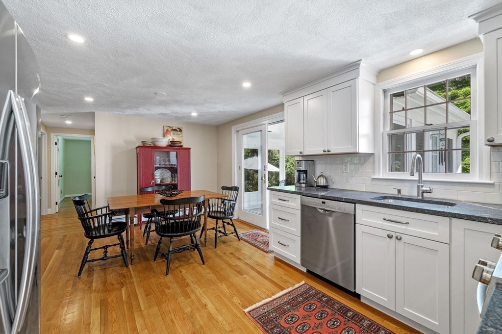 44 Walnut Road Hamilton, MA 01982 - Photo 12 of 39 a kitchen with stainless steel appliances granite countertop dining table chairs wooden cabinets and a window
