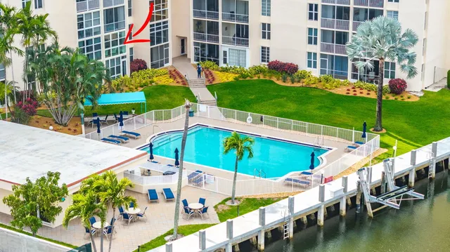 a view of an chairs and table in the patio with swimming pool