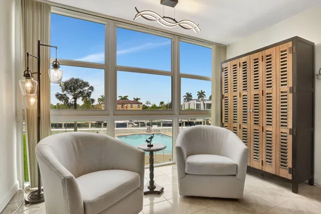 a living room with furniture a floor to ceiling window and a flat screen tv