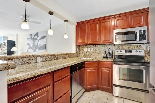 a kitchen with stainless steel appliances granite countertop a sink stove and microwave