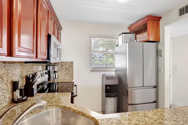 a kitchen with stainless steel appliances granite countertop a refrigerator and a sink
