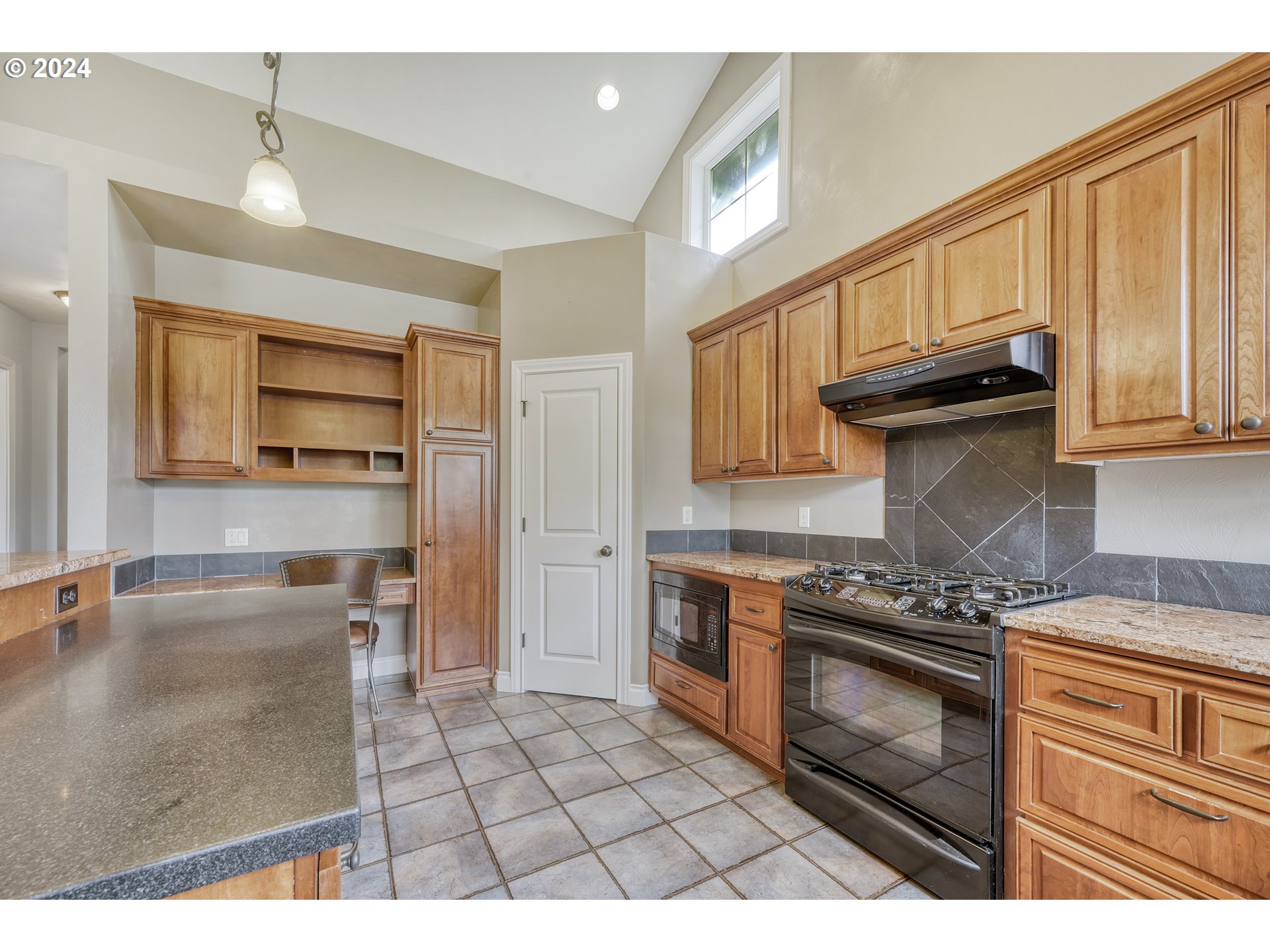 3349 Roanoke Avenue Eugene, OR 97408 - Photo 13 of 36 a kitchen with granite countertop a stove a sink and a microwave