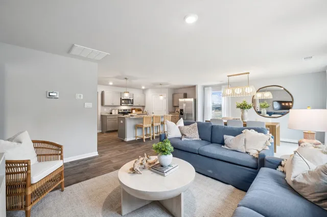 a living room with furniture and view of kitchen