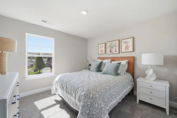 a bedroom with a bed and a lamp on the table
