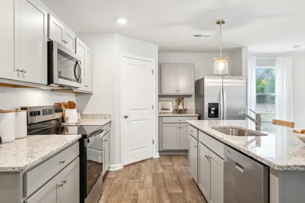 a kitchen with stainless steel appliances granite countertop a sink stove and refrigerator