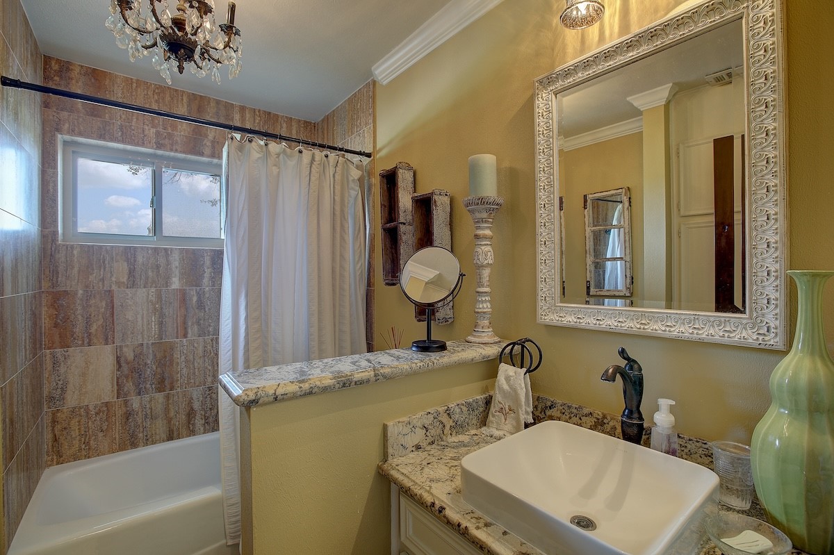 4214 Old College Road La Grange, TX 78945 - Photo 36 of 42 a bathroom with a granite countertop sink mirror and a bathtub