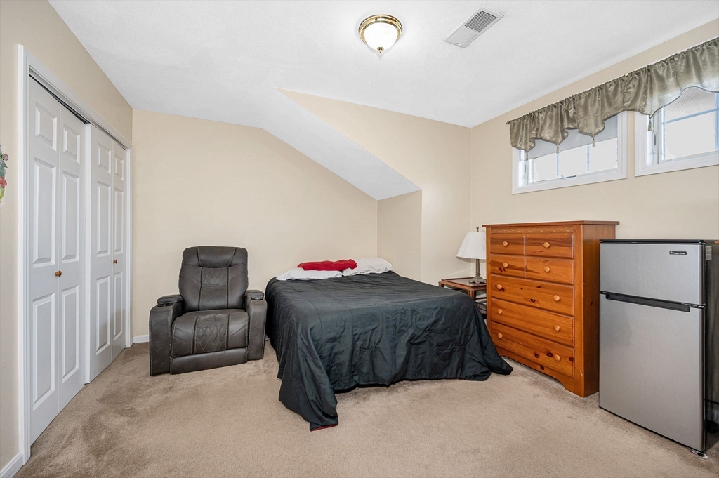 39 Broadway, Unit 305 Malden, MA 02148 - Photo 24 of 36 a bedroom with a bed and chair
