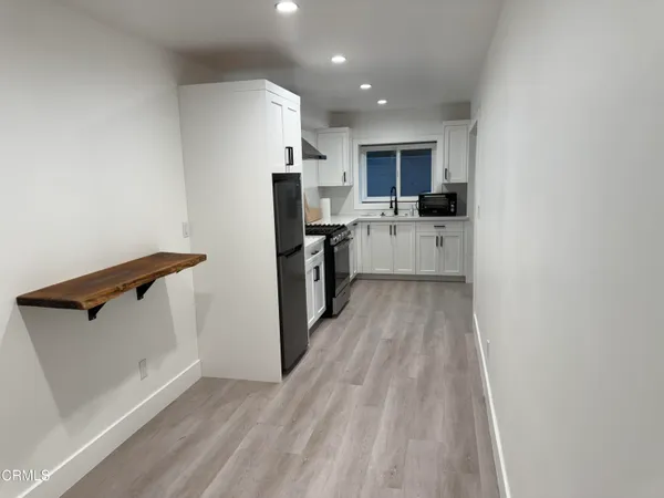 a view of kitchen with refrigerator stove microwave and cabinets
