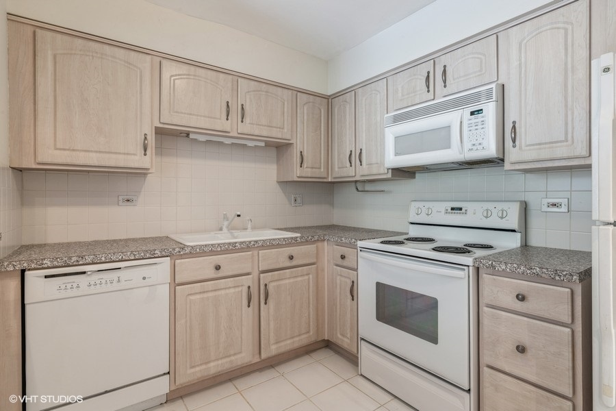 1400 North Elmhurst Road, Unit 411 Mount Prospect, IL 60056 - Photo 7 of 13 a kitchen with white cabinets and white appliances