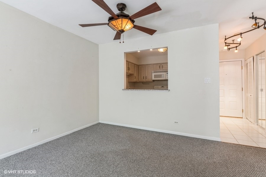 1400 North Elmhurst Road, Unit 411 Mount Prospect, IL 60056 - Photo 8 of 13 an empty room with a window and a ceiling fan