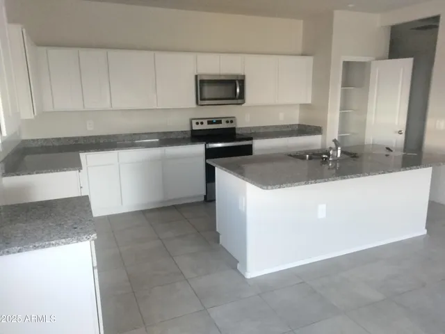 a kitchen with a sink stove and cabinets