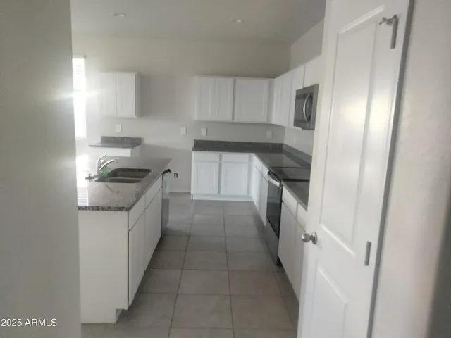 a kitchen with granite countertop a refrigerator and a sink