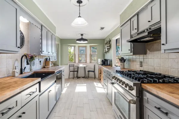 a kitchen with kitchen island granite countertop a sink stove and cabinets