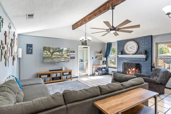 a living room with furniture a fireplace and a ceiling fan