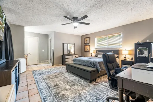 a living room with a bed furniture and a flat screen tv