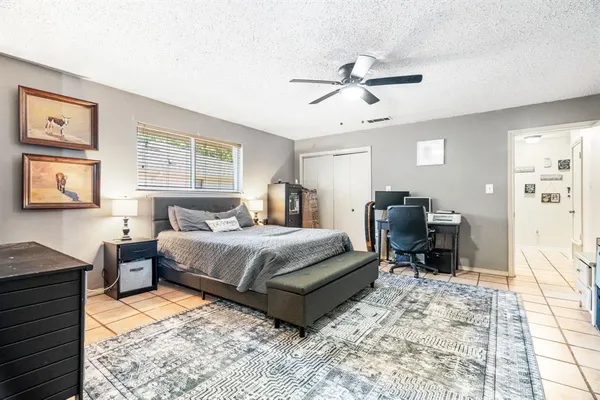 a spacious bedroom with a bed a desk and chair