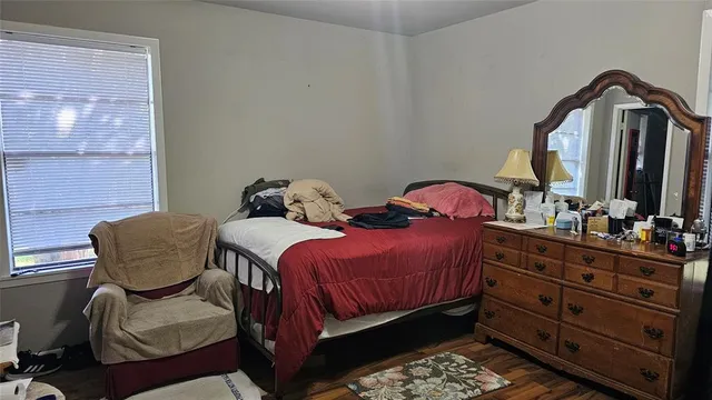 a bedroom with a bed and dresser with mirror