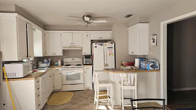 a kitchen with stainless steel appliances granite countertop a white cabinets and a refrigerator
