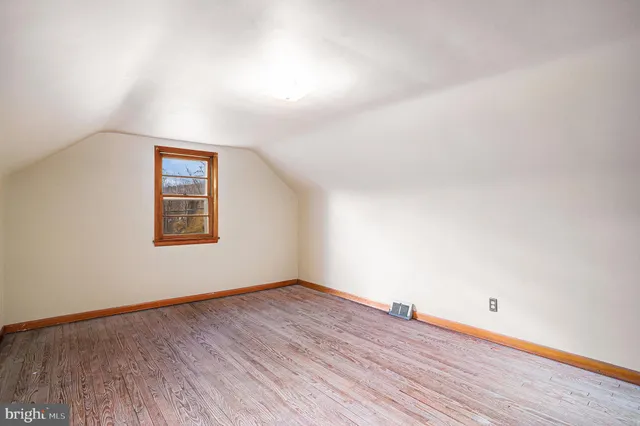 a view of a room with wooden floor and white walls