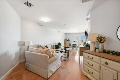 a living room with furniture and view of kitchen