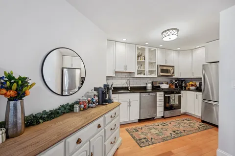 a kitchen with stainless steel appliances granite countertop a refrigerator sink and stove