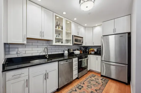 a kitchen with granite countertop a refrigerator a sink and dishwasher