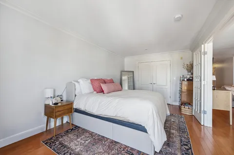 a bedroom with a bed and wooden floor